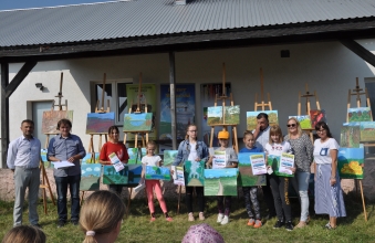 Uczestnicy pleneru malarskiego obok swoich prac