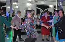 Trzymajace sie za rece kobiety tanczace w kolku