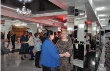 Dwie kobiety i grupa ludzi bawiaca sie do muzyki