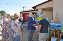 Dwoje mężczyzn przy obrazach na tle budynku 