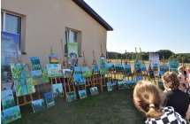 Publiczność pleneru malarskiego oglądająca wystawę obrazów 