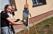 Dwie uśmiechnięte dziewczynki podczas malowania obrazu 