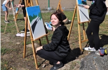 Uśmiechnięta dziewczyna pracująca nad obrazem 