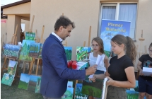 Dwie dziewczynki otrzymujące dyplomy od mężczyzny 