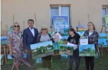 Cztery kobiety i mężczyzna na tle obrazów 
