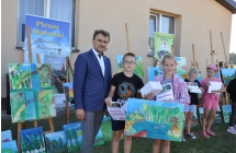 Chłopiec i dziewczynka z mężczyzną. Dzieci trzymają obraz 