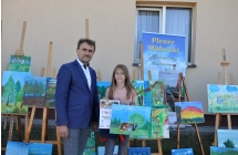 Mężczyzna z dziewczynką trzymającą dyplom i obraz 