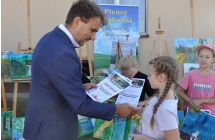 Elegancko ubrany mężczyzna wręczający dyplom dziewczynkom 