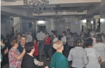 Grupa ludzi bawiących się do muzyki na parkiecie 