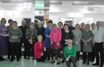 Kilkunastu członków stowarzyszenia w eleganckich ubraniach na sali w restauracji 