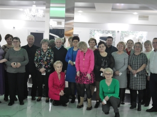Kilkunastu członków stowarzyszenia w eleganckich ubraniach na sali w restauracji 