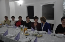 Siedem uśmiechniętych kobiet. Siedzą przy stole w restauracji 