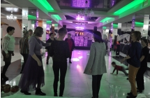 Kilkanaście osób bawiących się do muzyki na sali w restauracji 