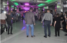 Kilkadziesiąt osób bawiących się na parkiecie w sali restauracyjnej 