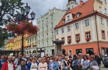 Uczestnicy wycieczki na tle zabytkowych budynków 