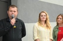Mężczyzna mówiący do mikrofonu, obok dwie kobiety 