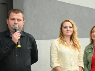 Mężczyzna mówiący do mikrofonu, obok dwie kobiety 